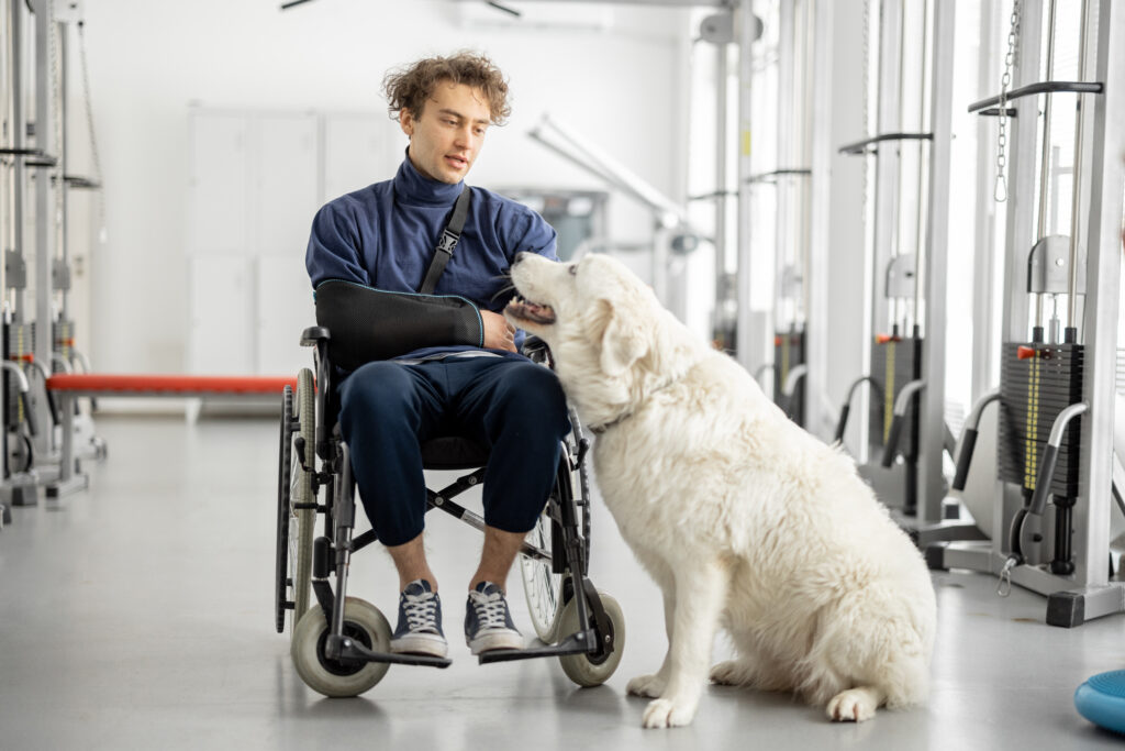 Guy with disabilities in a wheelchair with his assistance dog at rehabilitation center